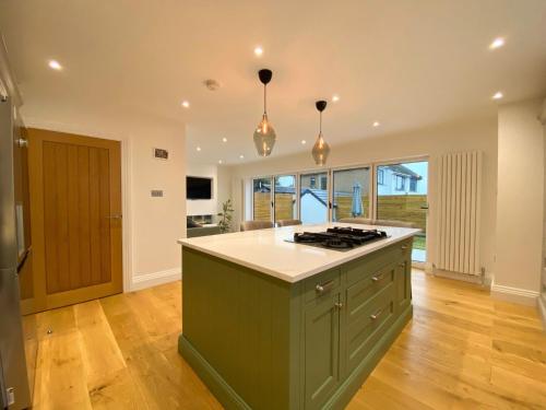 a kitchen with a green island in the middle of a room at House - Sleeps 9 & Private Garden in Leeds