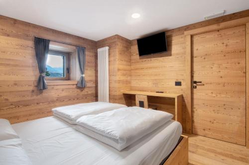 a bedroom with a bed and a television in it at Agriturismo Montespluga in Madesimo