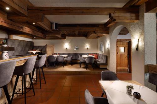 a restaurant with wooden ceilings and tables and chairs at Hotel Königsleiten Vital Alpin in Königsleiten