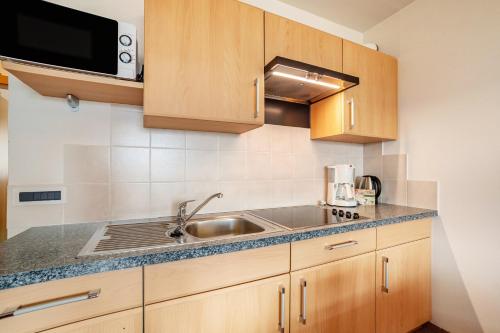 a kitchen with a sink and a microwave at Pension Klausthaler in Meltina