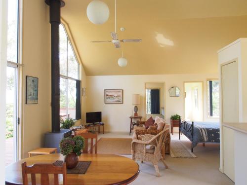 - un salon avec un canapé et une table dans l'établissement Bundle Hill Cottages, à Bawley Point