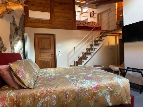 a bedroom with a bed and a staircase at Le Relais du Bourg Chambres de charme Wellnes in Donnas