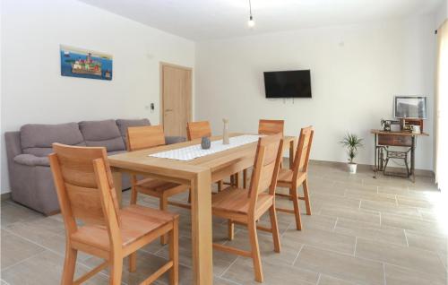 a dining room with a table and chairs and a couch at Three-Bedroom Holiday Home In Dugogabe in Dugobabe