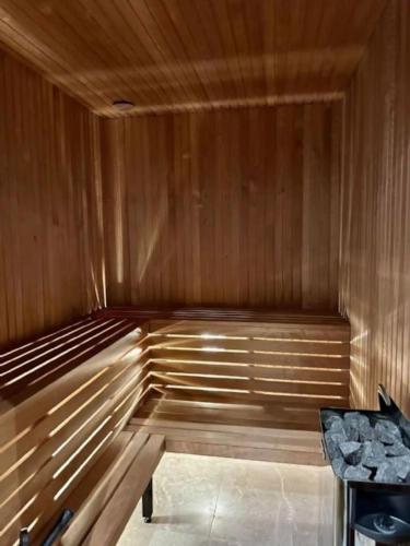 a wooden sauna with a bench and a table at Nybyggd villa i Storhogna in Storhågna