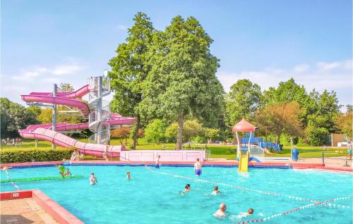 a group of people in a swimming pool with a water slide at 2 Bedroom Gorgeous Home In Heinkenszand in Heinkensand