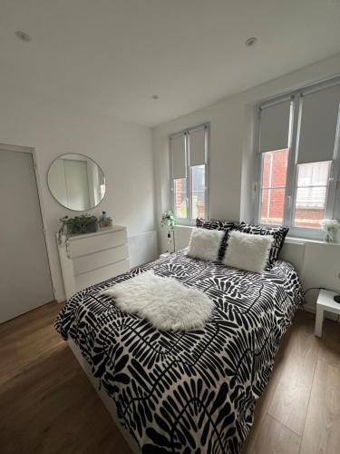 une chambre avec un lit noir et blanc et un miroir dans l'établissement DAUTRESIRE, au Tréport