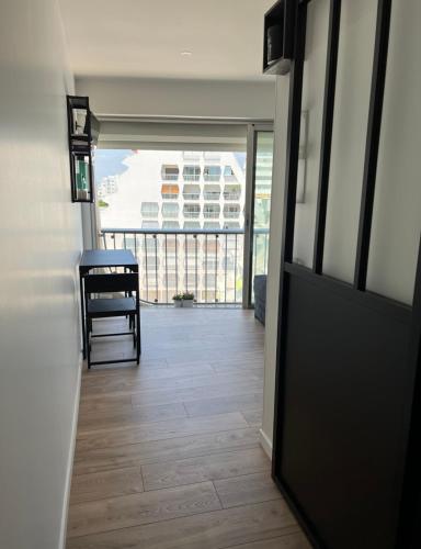 un couloir avec une porte, une chaise et un balcon dans l'établissement Studio rénové en plein centre ville, sur le port, vue mer, à La Grande Motte