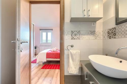 Un baño con lavabo y una cama en una habitación. en Villa Lasa, en Pazin
