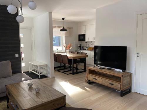 a living room with a flat screen tv and a table at Modern lägenhet i Sälen-Lindvallen in Sälen