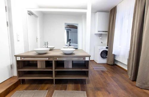 a bathroom with two sinks and a washing machine at Goldene Pastete - Urban Luxury Apartments City Center in Graz