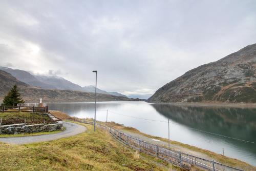 a winding road next to a lake in the mountains at Agriturismo Montespluga in Madesimo