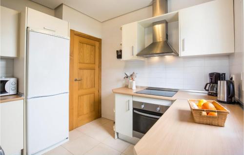 una cucina con elettrodomestici bianchi e un cesto di frutta su un bancone di 2 Bedroom Lovely Home In Roldan a Roldán