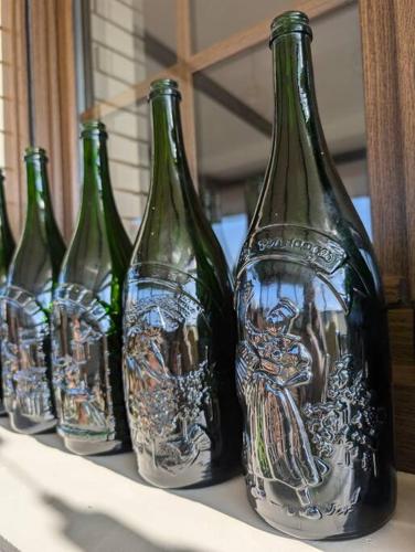 un groupe de bouteilles de vin posées sur une table dans l'établissement Maison Chez Papy Chapeau 4 étoiles, à Leuvrigny