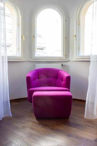 a purple couch in a room with two windows at Goldene Pastete - Urban Luxury Apartments City Center in Graz