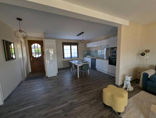 a kitchen and living room with a table and a couch at Maison Chez Papy Chapeau 4 étoiles in Leuvrigny