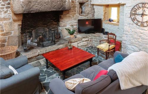 un salon en pierre avec une table et une cheminée dans l'établissement Lovely Home In Plouguerneau With Wifi, à Plouguerneau