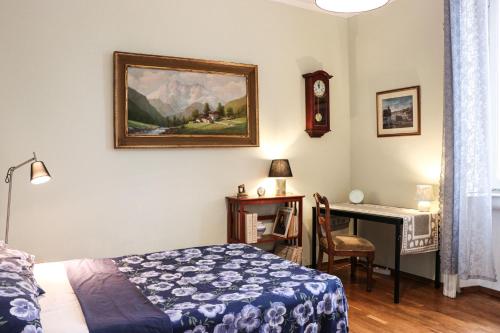 Un dormitorio con una cama y un escritorio con reloj. en Lili House, en Milán