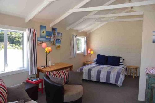 um quarto com uma cama e um sofá em Le Loft em Akaroa