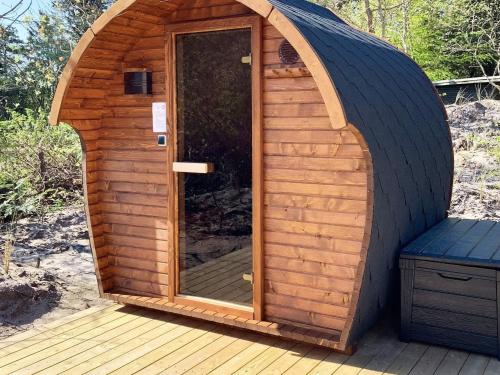 a wooden sauna with a glass door on a deck at 5 star holiday home in Vestervig-By Traum in Vestervig