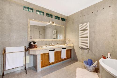 a bathroom with a sink and a mirror and a tub at Casa da Cidade de Loulé in Loulé