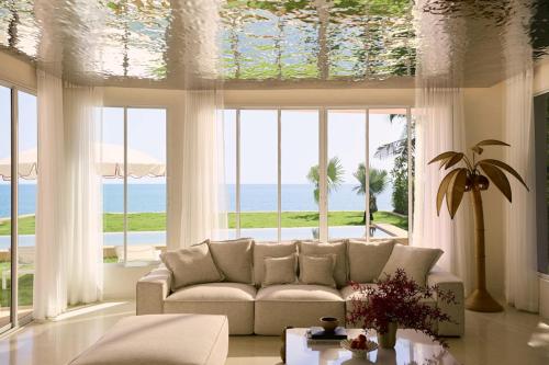 a living room with a couch and a large window at Mahi-Mahi Beachfront Villa by Yudee Assets in Cha Am