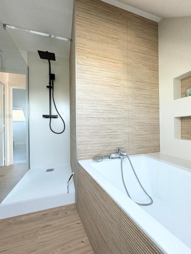 une salle de bain avec baignoire et douche dans l'établissement Villa Bel'Odet, appartements modernes au calme, terrasses pour les T2, grand jardin et parking gratuit, à 5 min des plages de Bénodet, à Clohars-Fouesnant