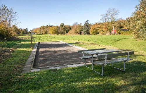 a picnic table and bench in a field at 3 Bedroom Stunning Pet-Friendly Home In Stubbekøbing in Stubbekøbing