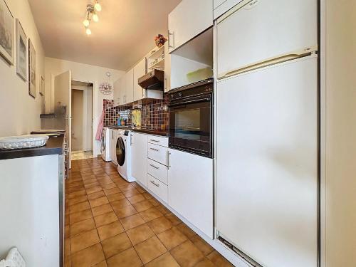  La cuisine est équipée de placards blancs et d'un réfrigérateur. dans l'établissement Luxury 1 bedroom Jardins Croisette 5 mins Croisette 265, à Cannes