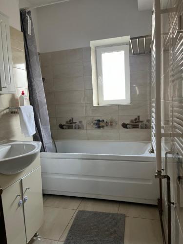 a white bathroom with a tub and a sink at Bucharest Airport Stay & Fly in Otopeni