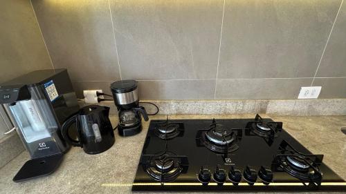 a stove top with a coffee maker and a coffeemaker at Dream House - Apto Lindo com Estacionamento Grátis! in Osasco