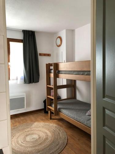 a room with two bunk beds and a window at chalet mitoyen en duplex in La Joue du Loup