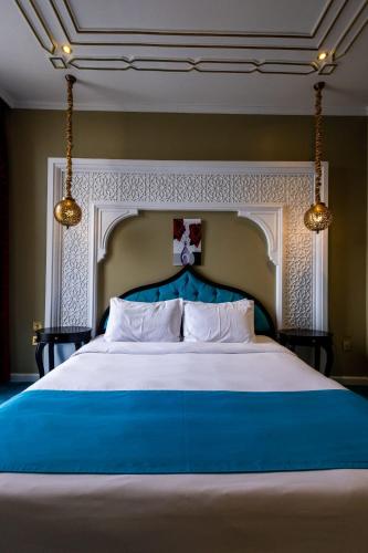 a large bed with a blue headboard in a bedroom at Saraya Corniche Hotel in Doha