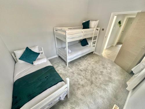 a small room with a bed and a shelf at 5 Bed House - Pool - Hot Tub - Sauna - Pool Table - Near New Forest and Beach - Sleeps 12 in Ringwood