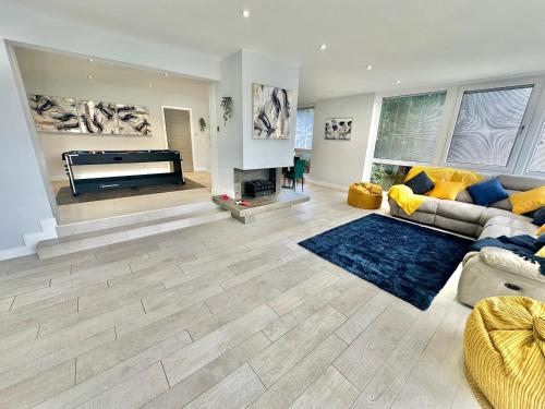 a living room with a couch and a piano at 5 Bed House - Pool - Hot Tub - Sauna - Pool Table - Near New Forest and Beach - Sleeps 12 in Ringwood