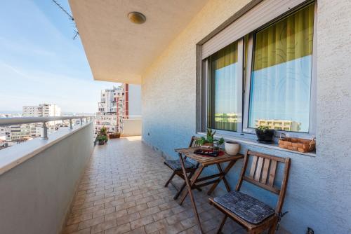 a balcony with two chairs and a table and a window at Main square apartment in Durrës