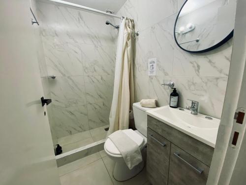 a bathroom with a shower and a toilet and a sink at Sur Alojamiento Ushuaia in Ushuaia