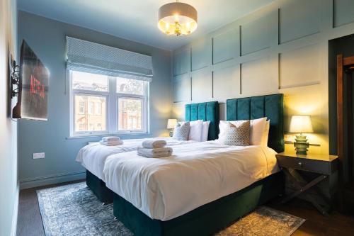 a bedroom with a large bed with blue walls at Emerald Park - HOT TUB & GAMES ROOM! in Scarborough