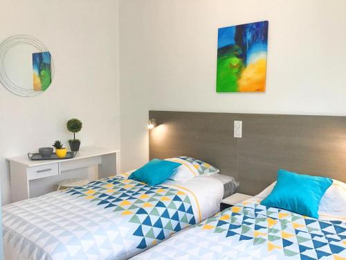 zwei nebeneinander stehende Betten in einem Schlafzimmer in der Unterkunft Appartement le Soleil 140 m2 climatisé parking privé proche Sanctuaires in Lourdes