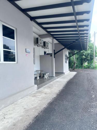 a large white building with a blue roof at Saliff Cottage 1 in Kampong Haji Musa