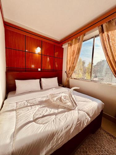 a bedroom with a large bed with a window at KBH by Royal Village in Singida