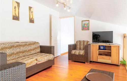 ラ・フォット・シュル・メールにあるBeautiful Home In La Faute Sur Merのリビングルーム(ソファ、椅子、テレビ付)