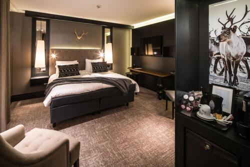 a bedroom with a bed and a desk and a chair at Lapland Hotels Oulu in Oulu