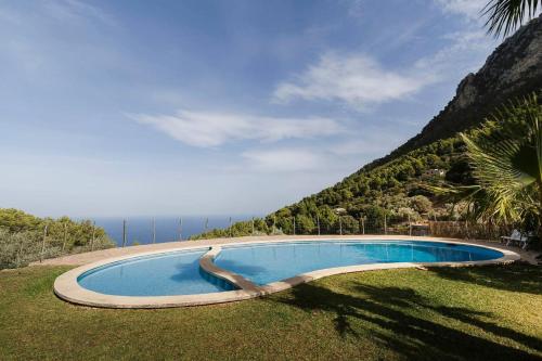 a swimming pool in the grass next to the ocean at Casa Tramuntana in Valldemossa