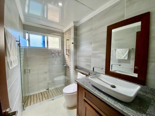 a bathroom with a sink and a shower and a toilet at Radiant Realm Residence Free Parking BBQ Central los Corales in Punta Cana