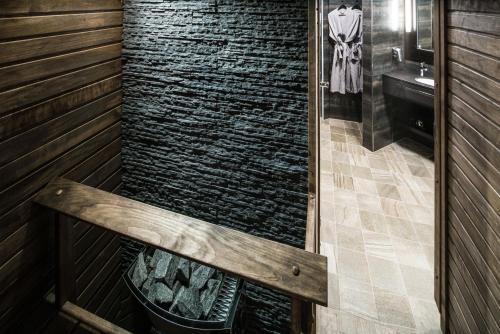 y baño con ducha de piedra y chimenea. en Lapland Hotels Oulu, en Oulu