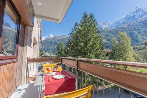 - un balcon avec une table et un bol de fruits dans l'établissement Appartement lumineux à Chamonix avec vue imprenable sur Mont Blanc et parking, à Chamonix-Mont-Blanc