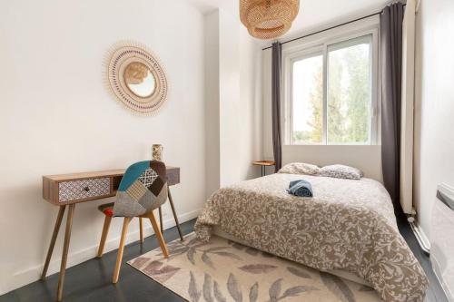 une chambre avec un lit, un bureau et une fenêtre dans l'établissement La Marcquoise, tramway Acacia 6 ch 5 sdb, à Marcq-en-Barœul