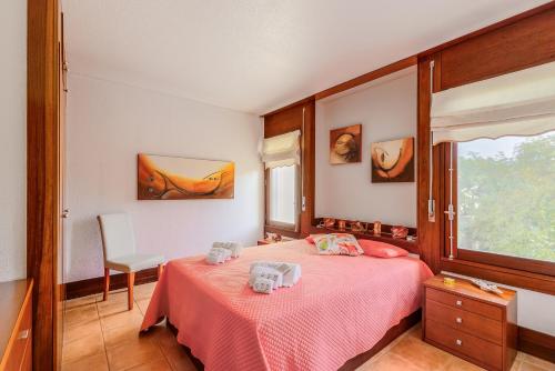 a bedroom with a pink bed and a window at Sunset Troia Beach in Troia