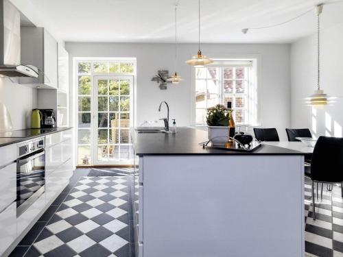a white kitchen with a black and white checkered floor at 4 star holiday home in Sæby-By Traum in Sæby
