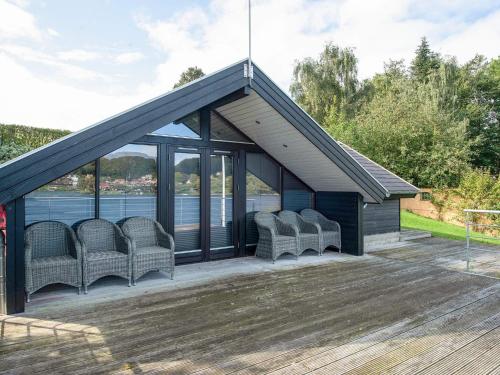 リューにある5 star holiday home in Ryの水辺のデッキに椅子が置かれたパビリオン